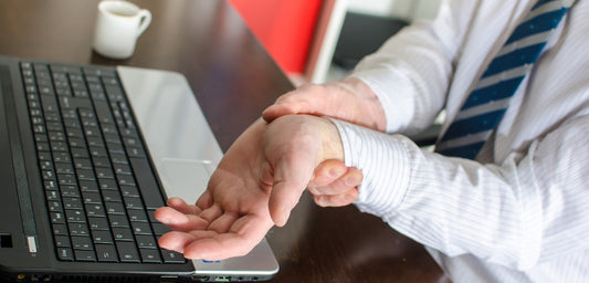 Photo of a businessman holding painful wrist 