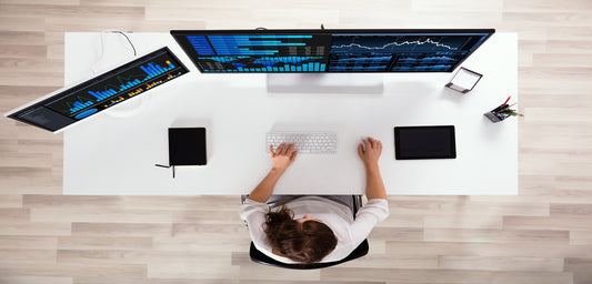 Photo of a woman analyzing graphs on a computer at workplace